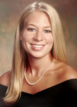 Portret de studio al lui Natalee Holloway, o tânără blondă zâmbitoare, fotografiată în ținută de absolvire și purtând un șirag de perle.
