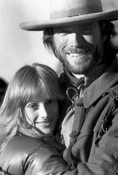 Sondra Locke și Clint Eastwood îmbrățișați în timpul filmărilor filmului „The Outlaw Josey Wales”, într-o fotografie alb-negru realizată în 1975.