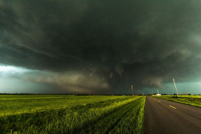 Tornada El Reno din 2013, o supercelulă uriașă cu nori întunecați, observată deasupra câmpiilor din Oklahoma, lângă o șosea rurală.