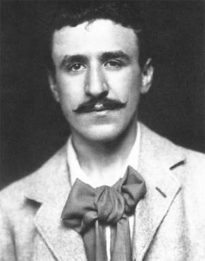 Portret alb-negru de epocă al tânărului arhitect și designer Charles Rennie Mackintosh, privind spre cameră, purtând sacou din tweed și o lavarieră proeminentă înnodată sub gât.