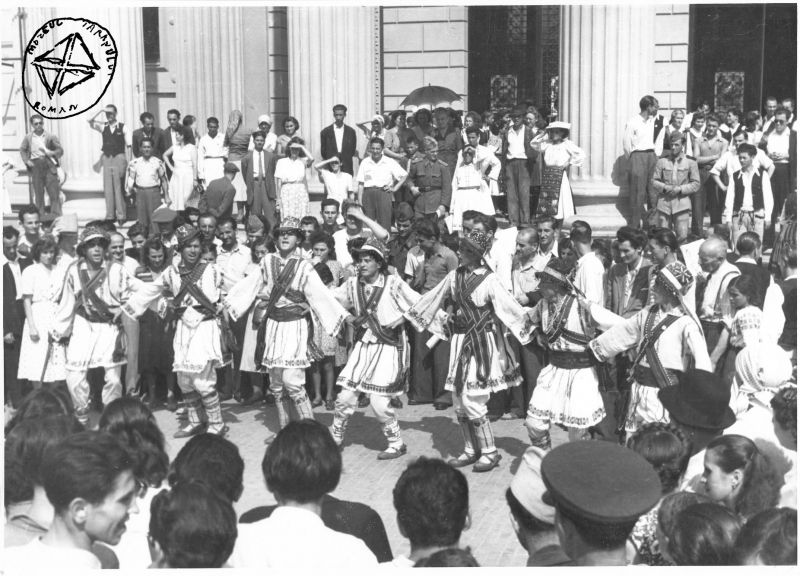 Fotografie alb-negru din 1951 înfățișând o ceată de călușari dansând în fața Ateneului Român, înconjurați de un numeros public.